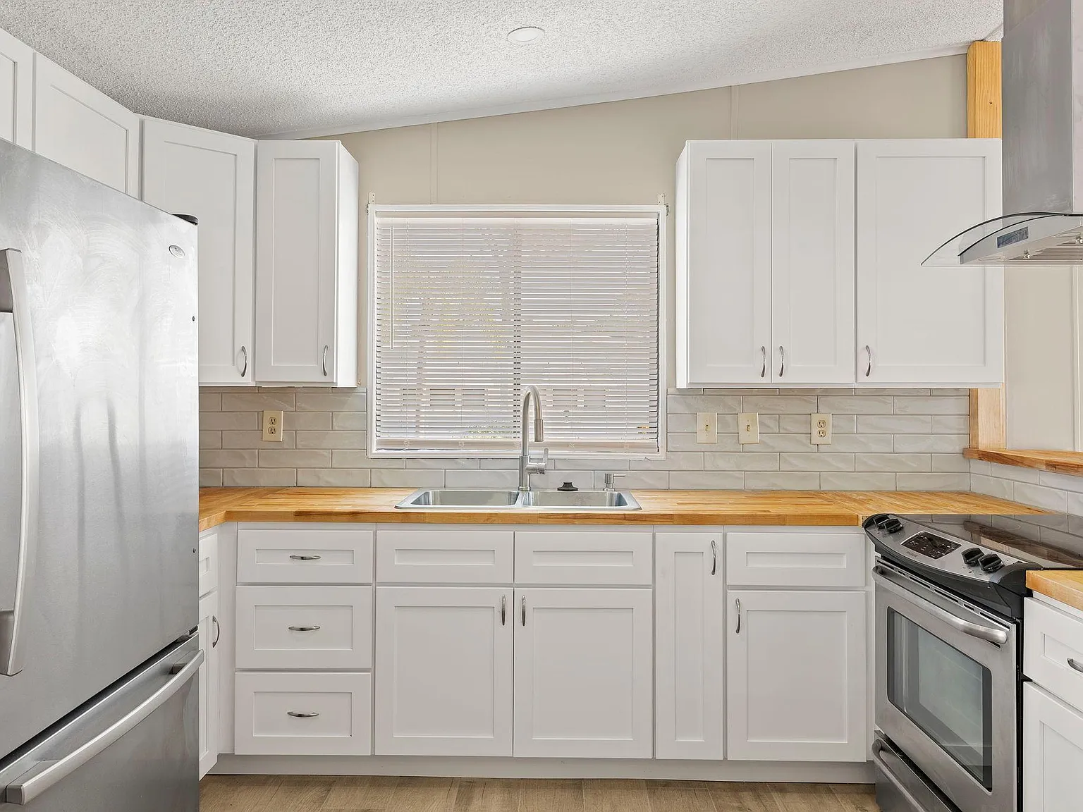 A couple smiling and holding keys in front of their new home